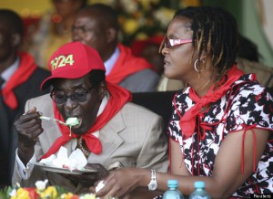 Zimbabwe's President Robert Mugabe eats cake next to his wife Grace during an event marking his 89th birthday in Bindura