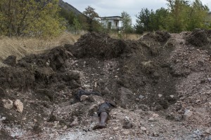 A dismembered body lies on a site where pro-Russian rebels say is a mass grave with five bodies in the town of Nizhnaya Krinka