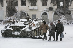 Locals walk past a destroyed Ukrainian army armoured personnel carrier in the town of Vuhlehirsk, west of Debaltseve