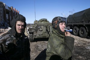Fighters with the separatist self-proclaimed Donetsk People's Republic smoke near an armoured personnel carrier in the village of Nikishine